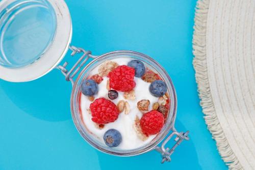 a glass jar filled with yogurt with berries and nuts at Bonavida Apartments in Port d'Alcudia