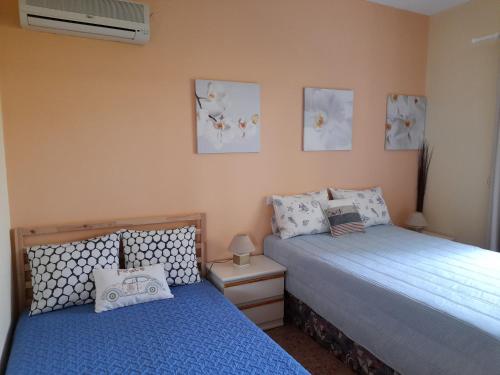 ein Schlafzimmer mit zwei Betten und einer Klimaanlage in der Unterkunft Lagonissi Summer House in Lagonisi