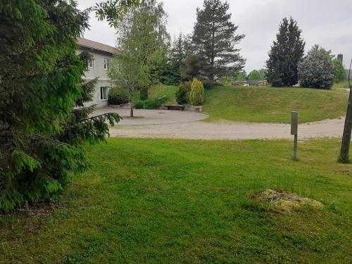 a park with a building and a driveway at Viesu nams Vizbulītes in Talsi