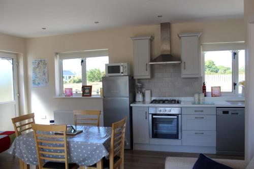 uma cozinha com uma mesa e uma cozinha com uma mesa e cadeiras em Ben Haven Self Catering Accommodation em Ballaghnatrillick