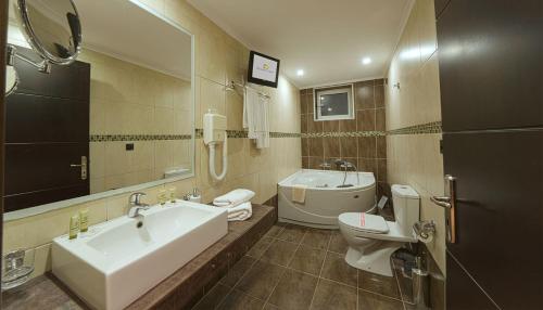 łazienka z wanną, toaletą i umywalką w obiekcie Amalias Hotel w mieście Kourouta