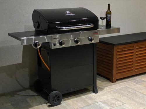 a grill with a bottle of wine on a table at Apartmány DOME in Doksy