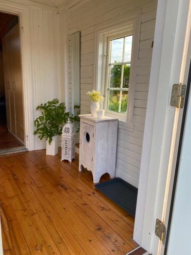 eine Veranda mit einem Vogelhaus und einem Fenster in der Unterkunft Lillstugan Lyckan in Kristdala