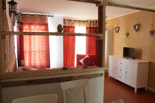 una camera con finestra con tende rosse di LE REFUGE DU COEUR a Pré-Saint-Didier