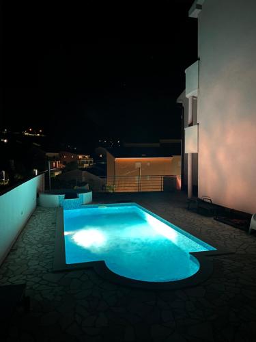 a night view of a swimming pool on a building at Apartments Ćosić in Klenovica