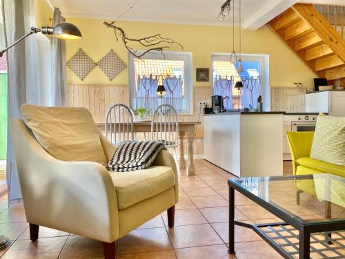 a living room with a chair and a table at Apartmenthaus Lütt Meer in Ludorf