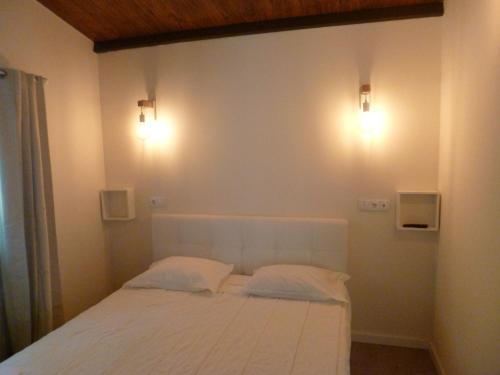 sypialnia z białym łóżkiem z 2 poduszkami w obiekcie Casas das Guimbras w mieście Geres
