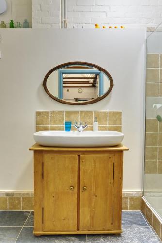 a bathroom with a sink and a mirror at Bramble Cottage in Whiteparish