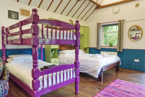 um quarto com 2 beliches num quarto em Bramble Cottage em Whiteparish