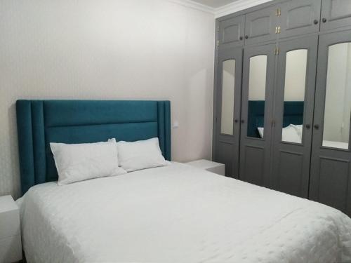 1 dormitorio con 1 cama grande y cabecero azul en Lili's Albufeira Apartment, en Albufeira