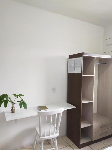 a white desk and a white chair in a room at Hotel Norte Blu in Blumenau