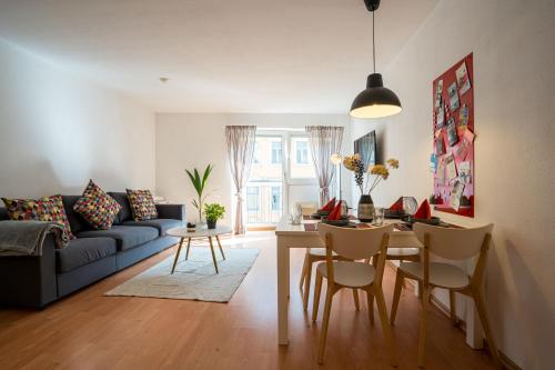 ein Wohnzimmer mit einem Sofa und einem Tisch mit Stühlen in der Unterkunft Große Louise in der Neustadt für Familien & Kinder in Dresden