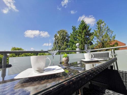 a table with cups and saucers on a balcony at Ferienwohnung Langeneß in Horumersiel