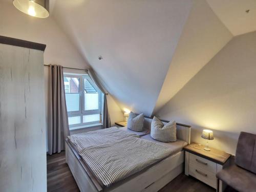 Schlafzimmer mit einem großen Bett und einem Fenster in der Unterkunft Ferienwohnung Langeneß in Horumersiel