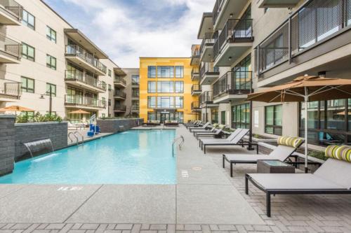 a swimming pool with chairs and umbrellas in a building at Modern Urban Apartments│On Roosevelt Row│Local Eat & Drink in Phoenix