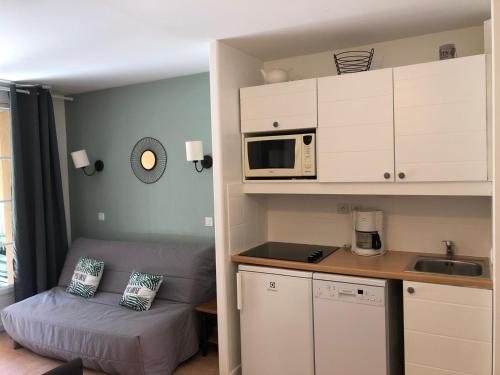 a small kitchen with a bed and a microwave at Bonheur in Monflanquin