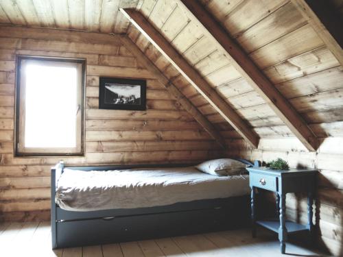 a bed in a wooden room with a window at Chalet Lily in Žabljak