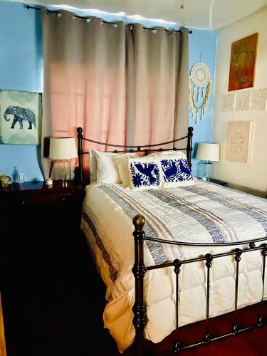 a bedroom with a bed with blue walls at Ne Miami Cottage in Miami