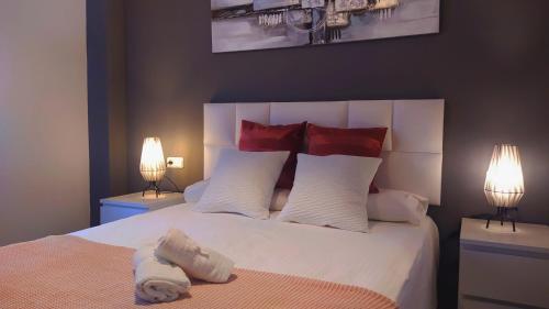 a bedroom with a large white bed with two lamps at BEACH&GARDEN in Málaga