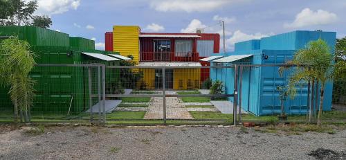 a colorful house behind a fence in front at Mandala House Container in Chapada dos Guimarães