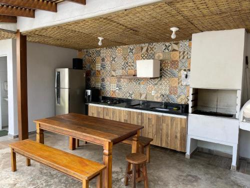 a kitchen with a wooden table and a refrigerator at Casa em Condomínio Maresias in São Sebastião