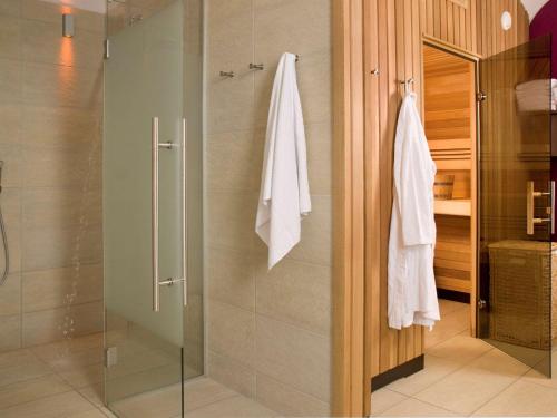 uma casa de banho com um chuveiro e uma porta de vidro em Mercure Grand Hotel Biedermeier Wien em Viena