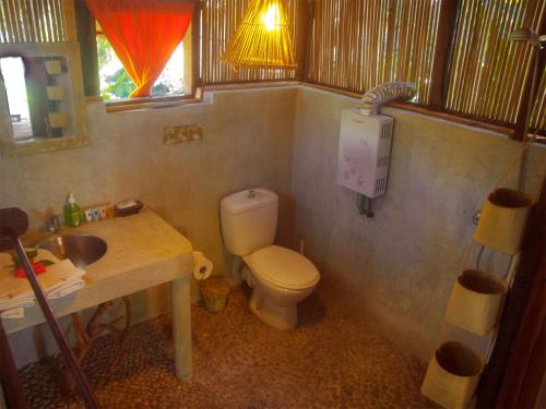 a small bathroom with a toilet and a sink at Baboo Village in Ile aux Nattes