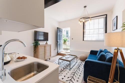 a kitchen and living room with a sink and a couch at 14-16 Grosvenor Street Stylish Apartments - Chester in Chester