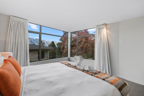 a bedroom with a bed with a large window at Lomond Retreat - Near CBD Executive Apartment in Queenstown