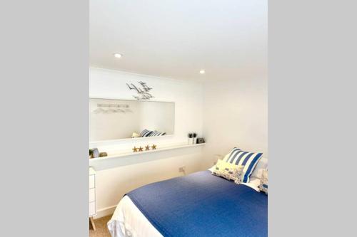 a bedroom with a blue bed and a white wall at Luna Beach - Luxury Carbis Bay Apartment + Parking in Carbis Bay