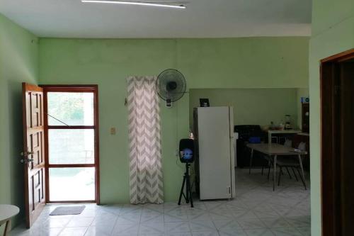 a room with a refrigerator and a table with a window at CASA CON TODO LOS SERVICIOS Y 2 RECAMARAS CLIMATIZADAS CON 2 CAMAS CADA UNO PARA 8 PERSONAs in Tecolutla