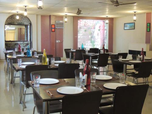 a dining room with tables and chairs with empty plates at Ceyone Hotels in Mussoorie