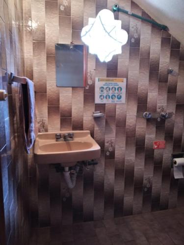 a bathroom with a sink and a sign on the wall at LA CASA DE DOÑA EMMA in Mazamitla