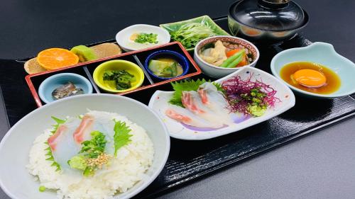 a tray with rice and vegetables and bowls of food at JR Hotel Clement Uwajima in Uwajima