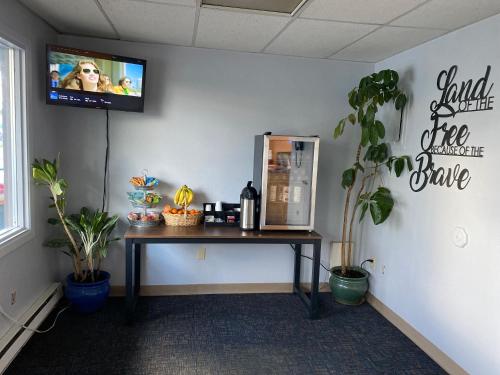 Golden North Inn في فيربانكس: غرفة مع طاولة وتلفزيون على الحائط