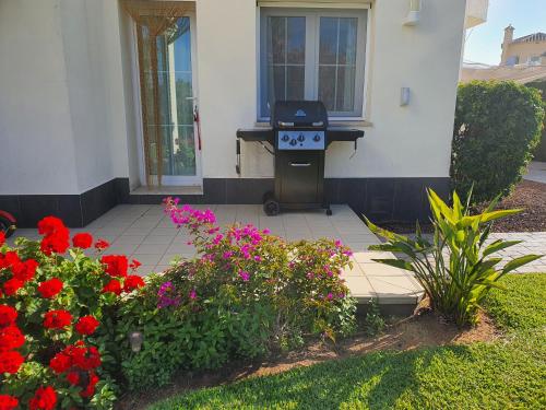 a house with a flower garden with red flowers at Villa Lujo Olivanova Golf MET in Oliva