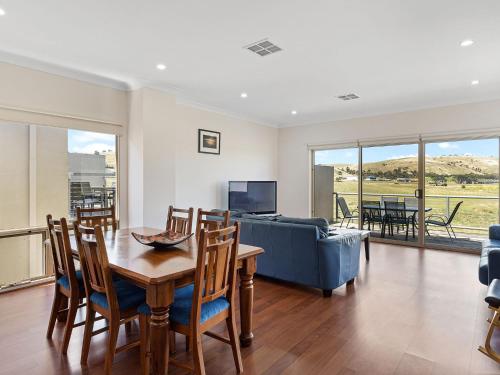 a living room with a table and a blue couch at 26 45 St Andrews Boulevard in Normanville