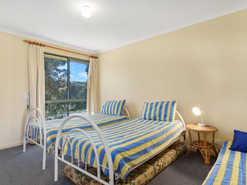 a bedroom with two beds and a window at 22 Broadbeach Drive in Normanville