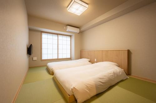 Postel nebo postele na pokoji v ubytování Fuji Hotel Kyoto Gojo