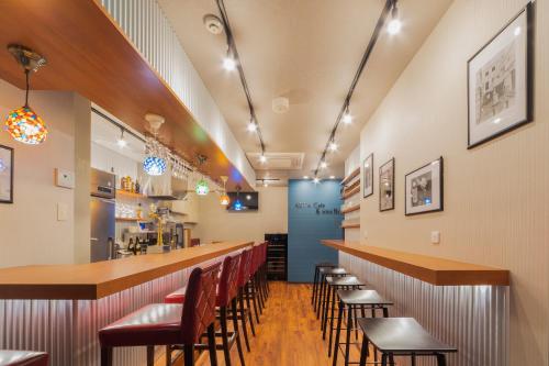 a restaurant with a long bar with chairs at Asta Hotel in Tokyo