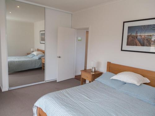 a bedroom with a bed and a mirror at Shearers Rest 5 Davey Road in Normanville