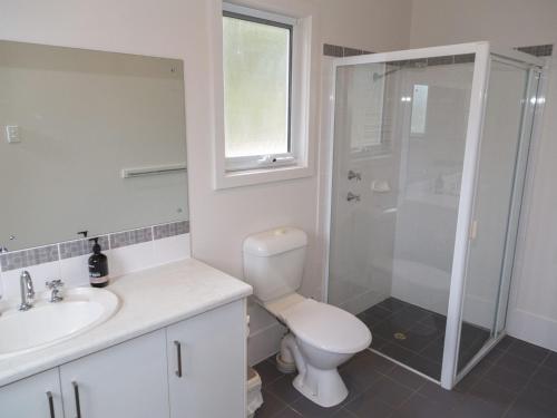 a bathroom with a toilet and a sink and a shower at Shearers Rest 5 Davey Road in Normanville
