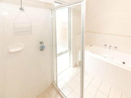 a white bathroom with a shower and a tub at Shearers Rest 5 Davey Road in Normanville