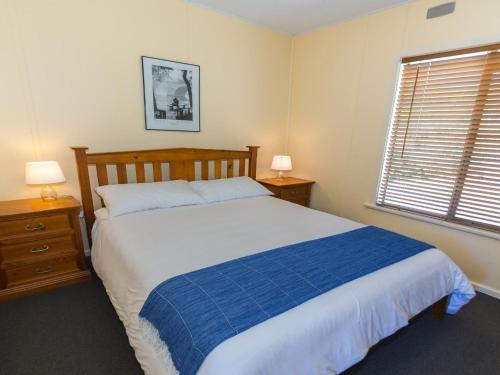 a bedroom with a large bed and two night stands at Sandy Feet 31 Gold Coast Drive in Normanville