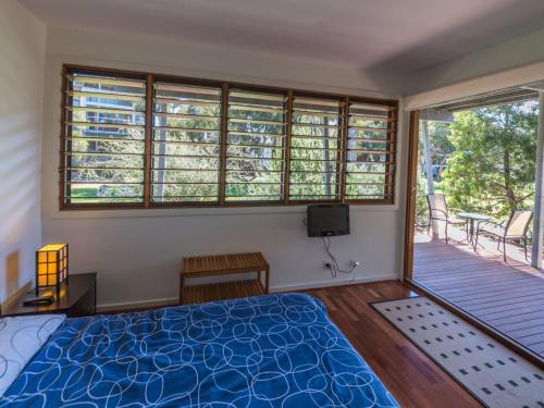 une chambre avec un lit et un balcon dans l'établissement South Shores Villa 52, à Normanville