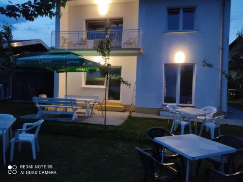 a patio with tables and chairs and an umbrella at Hacienda Bled Rooms in Bled