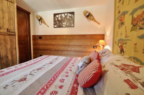 a bedroom with a bed with red and white pillows at Bilocale montano in La Thuile