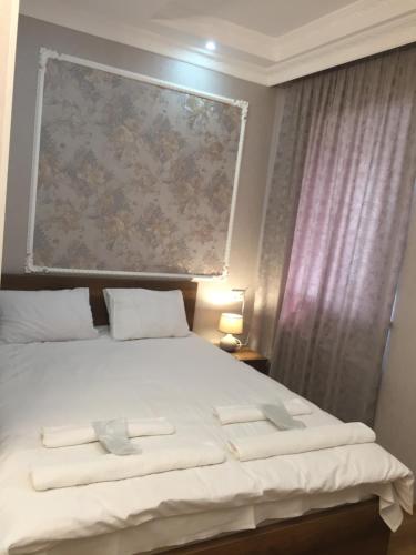 - une chambre avec un lit blanc orné d'une peinture murale dans l'établissement HOTEL COMFORT, à Koutaïssi