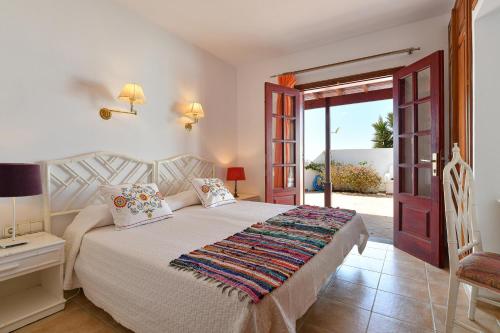 a bedroom with a bed and a door to a patio at Casa Maresia in Playa Honda