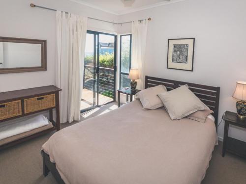 a bedroom with a large bed and a balcony at 20 Lady Bay Road in Normanville